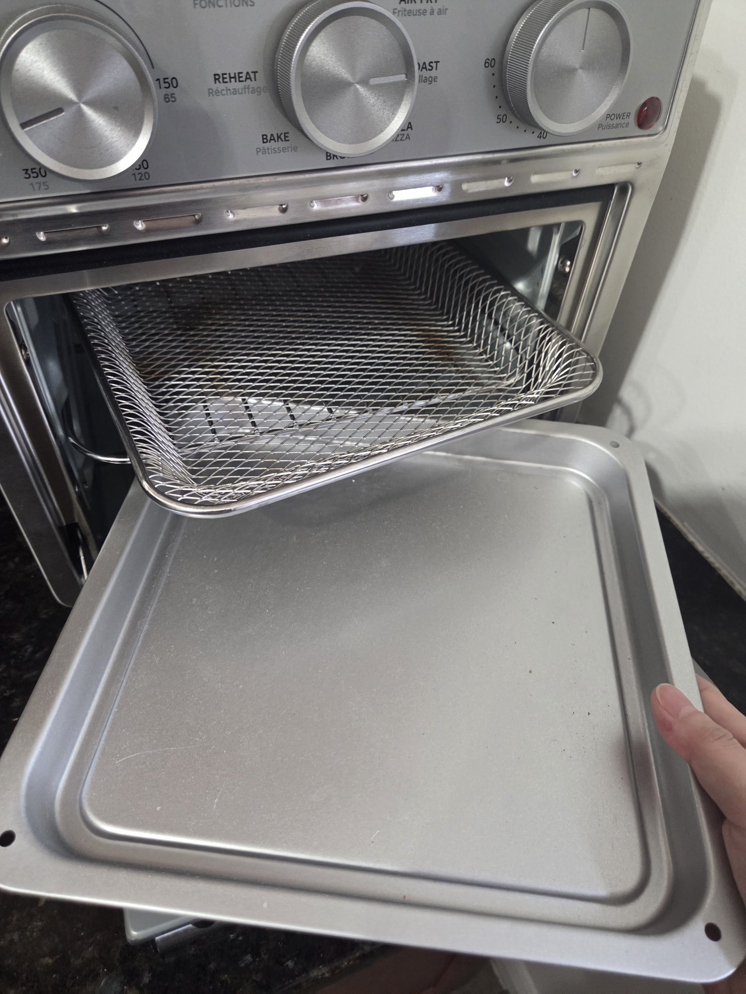 Air fry basket sliding into the oven on rack guides