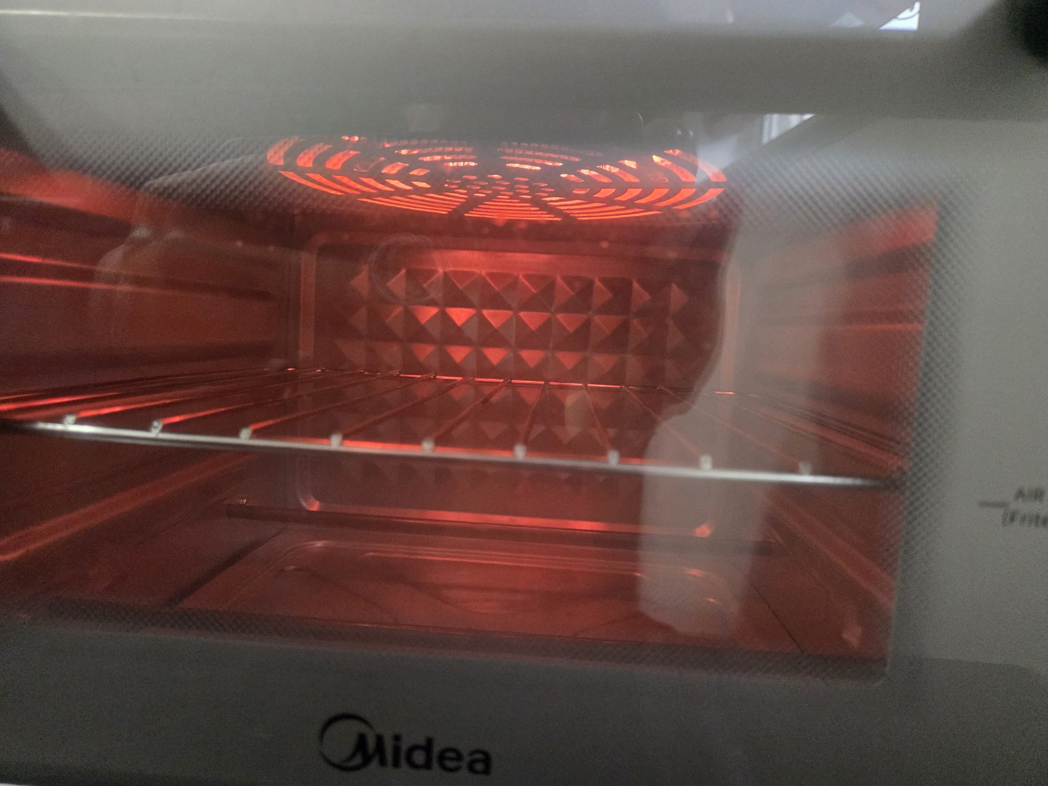 Heating element glowing during preheat, seen through the glass door