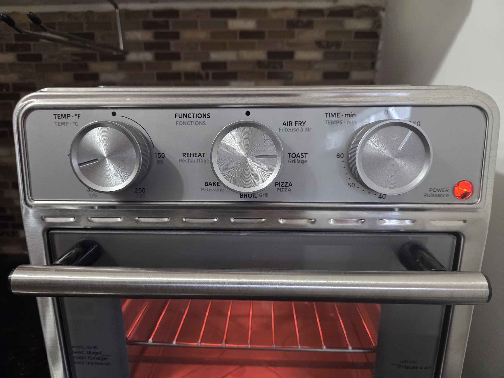 Close-up of the three control knobs: temperature, function, timer